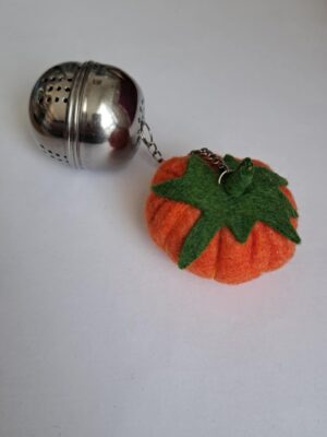 Infuseur à thé en métal décoré avec une citrouille en feutrine.