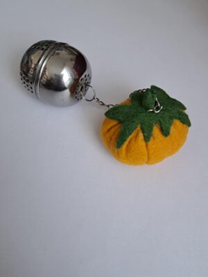 Infuseur à thé en métal décoré avec une citrouille en feutrine.